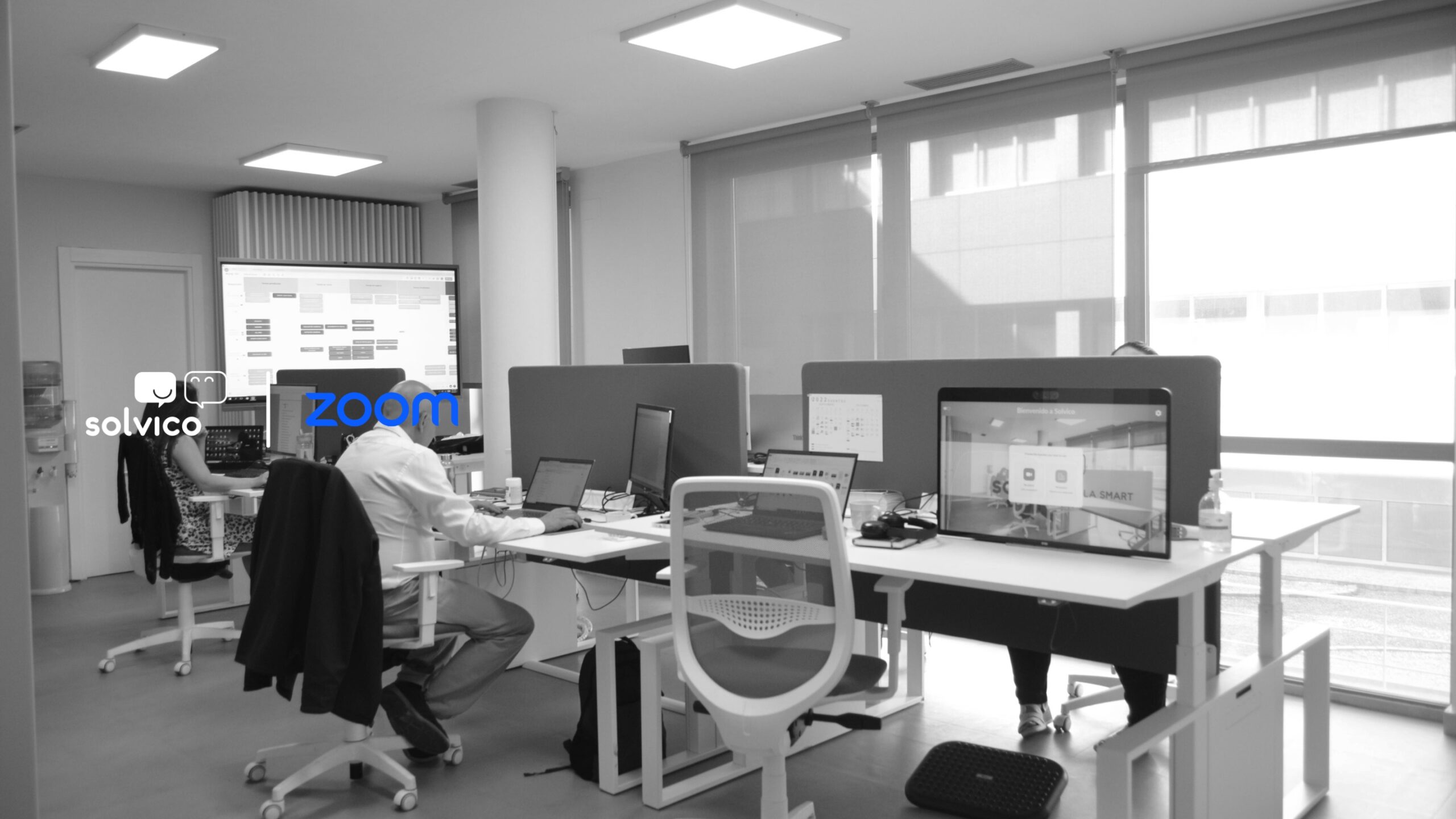 Oficina de Solvico con los logos de Zoom y Solvico como partners de comunicaciones unificadas